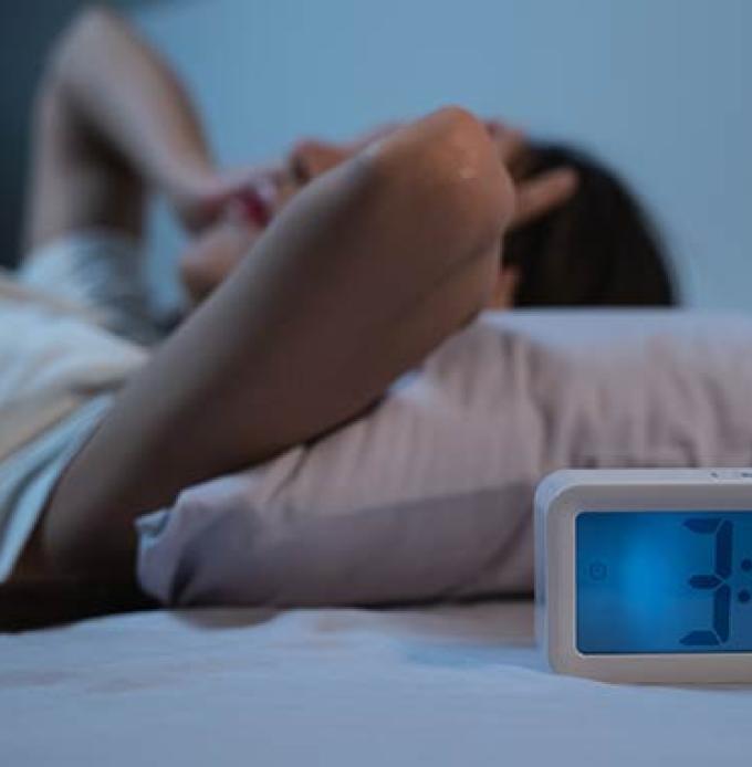 Gesch&auml;ftsfrau w&auml;lzt sich nachts im Bett weil Sie nur an die Arbeit denken muss (Foto: &copy; Pormezz, Adobe Stock)